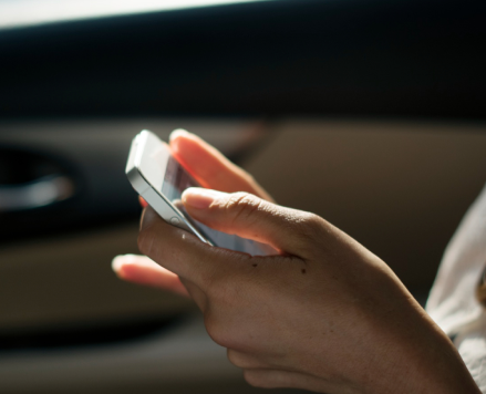 person-in-car-holding-phone